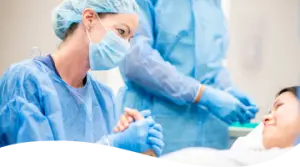 A female surgeon wearing a mask and gloves
